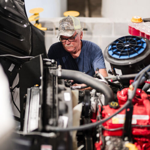 Experienced technician working on a diesel truck engine during cooling system maintenance. Midtex Oil supplies extended life antifreeze coolant, offering antifreeze wholesale solutions and distribution services for fleets, transportation companies, and industrial customers.